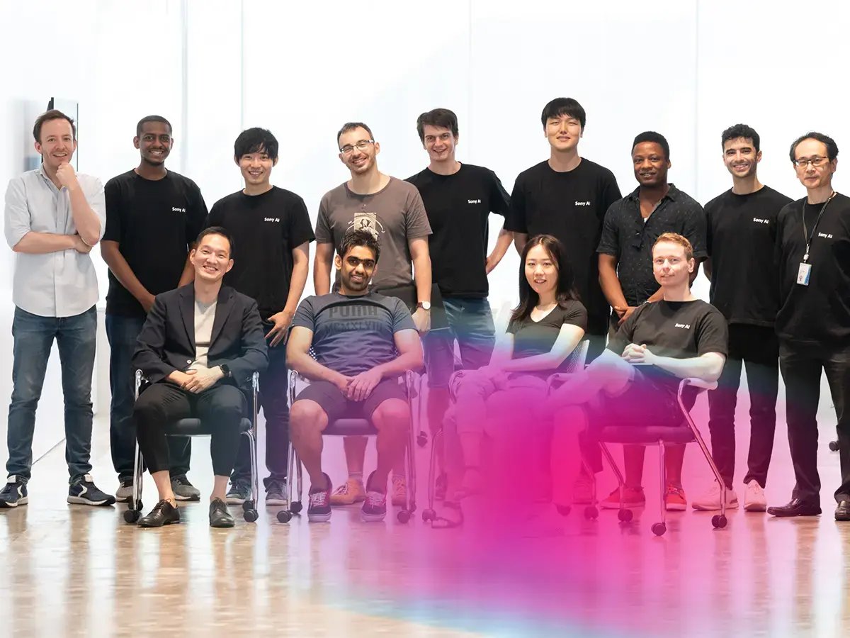 A diverse group of people poses in a brightly lit office