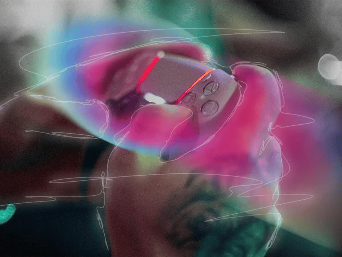 A hand tightly grips a gaming controller, surrounded by vibrant neon hues and swirling lines