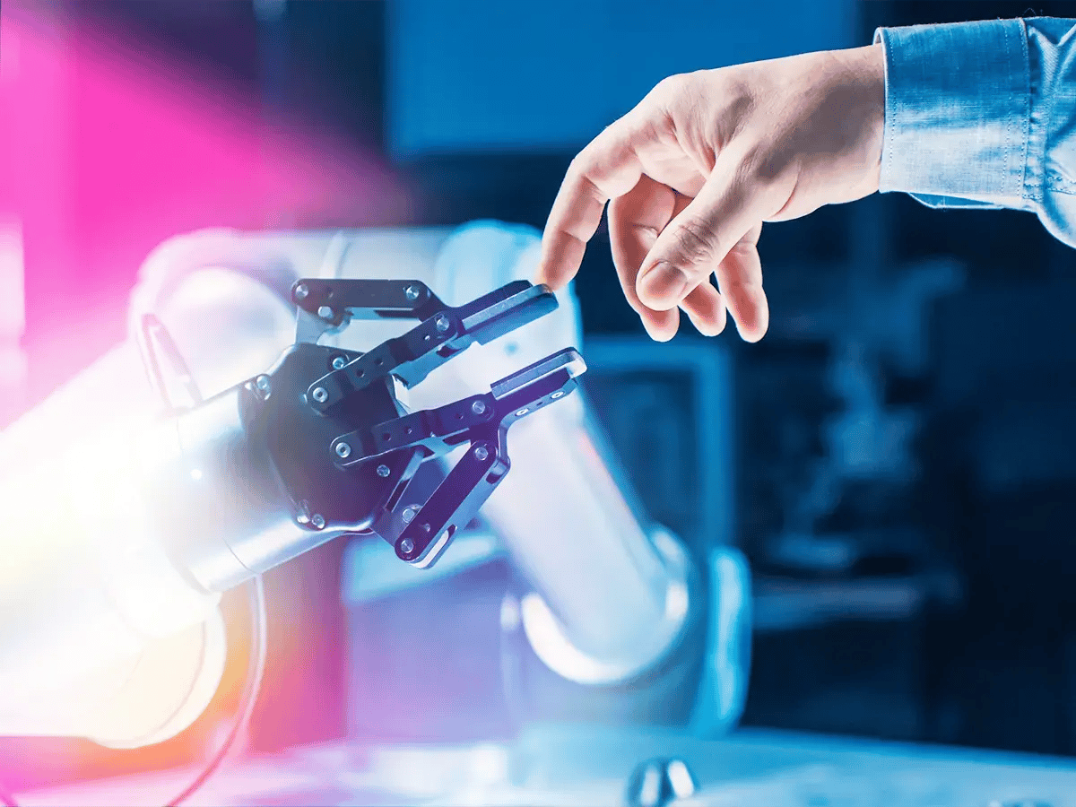 A human hand reaches towards a robotic hand, nearly touching fingertips