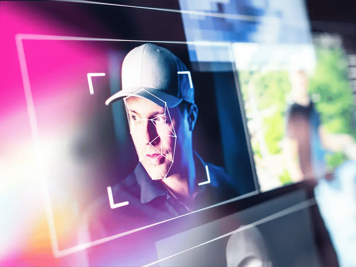 A man in a cap is framed by facial recognition lines on a digital screen