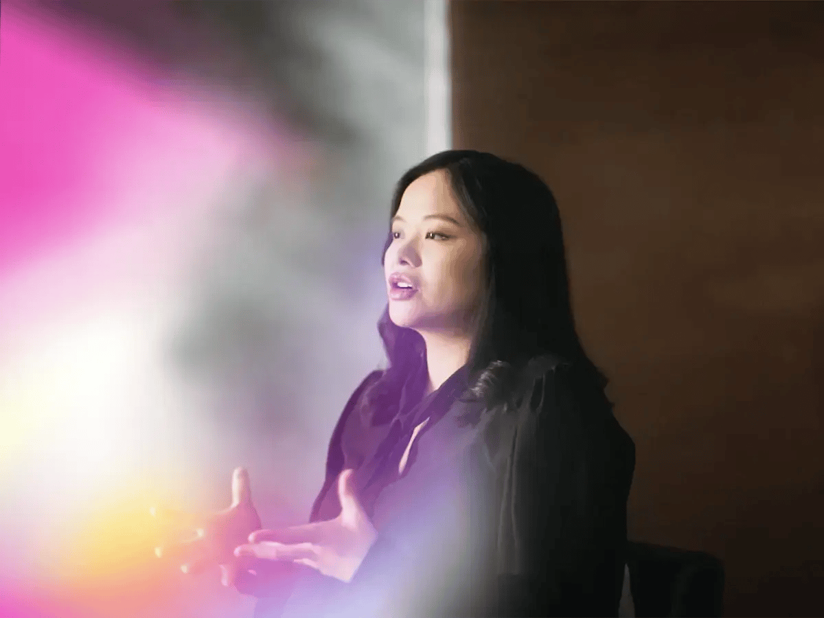 A woman speaks passionately, gesturing with her hands