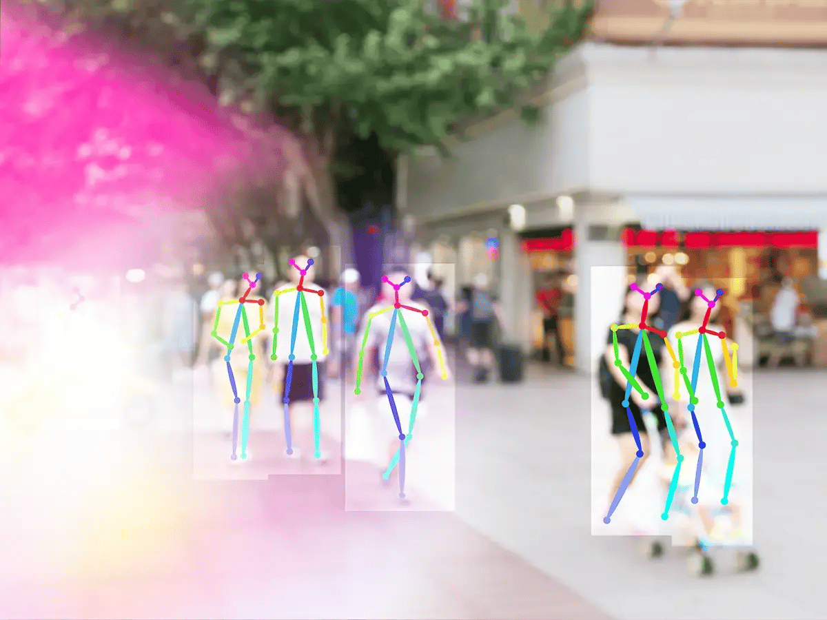 Blurred background of a busy street with colorful stick figure overlays on moving pedestrians