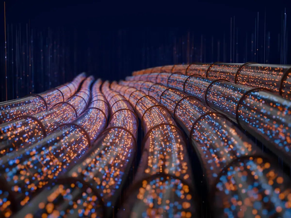 Curved transparent tubes filled with glowing blue and orange dots stretch across a dark background